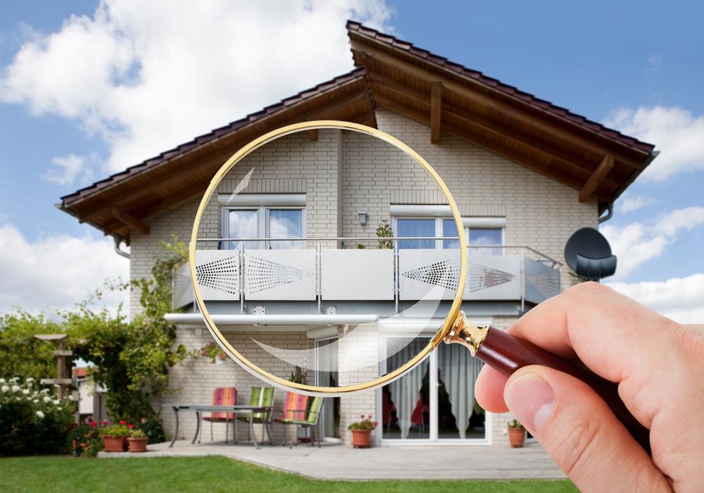 Image of a house with a large magnifying glass inspecting the premises