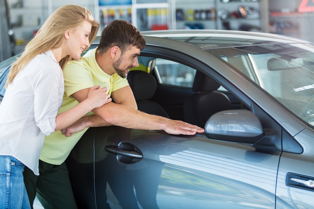 Couple looking at a car in a showroom before buying