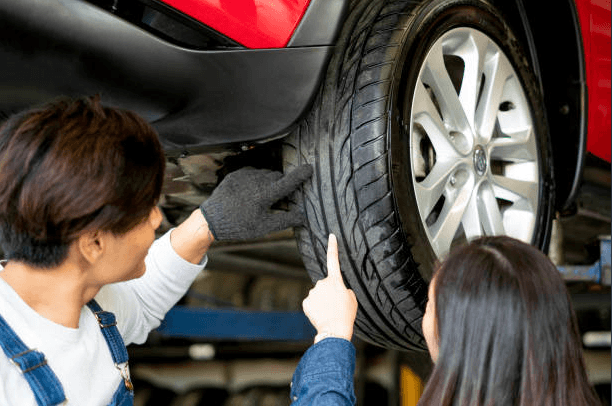 checking tyre wear on a car in a garage