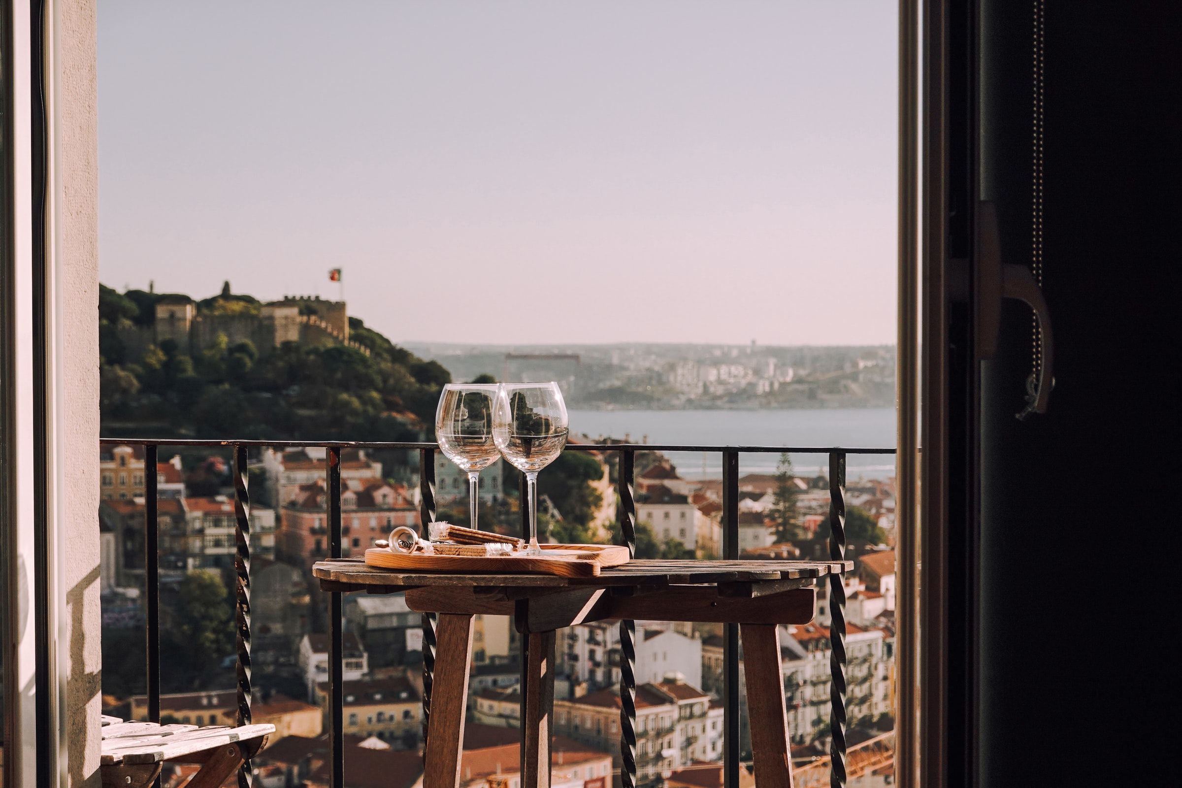 table with two full glasses of wine, balcony of a rental house