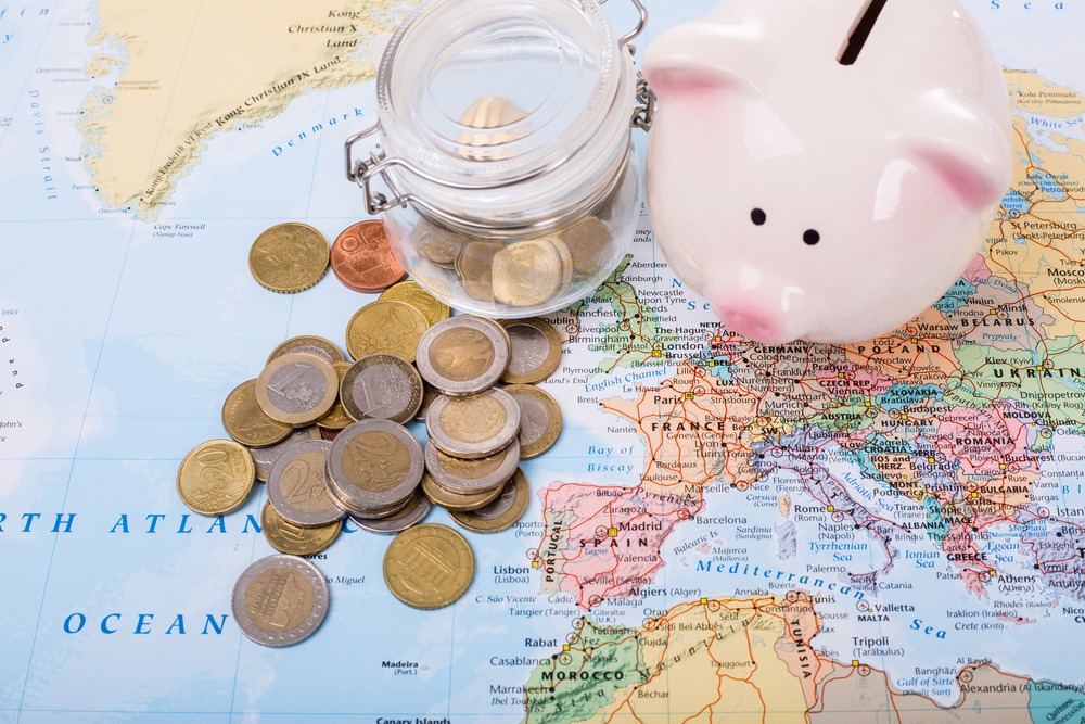 représentation d'une carte de l'Europe sur laquelle on voit des pièces de monnaie et une tirelire