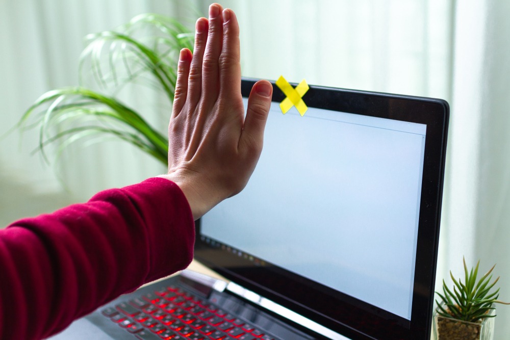 Hand covering a computer screen's webcam
