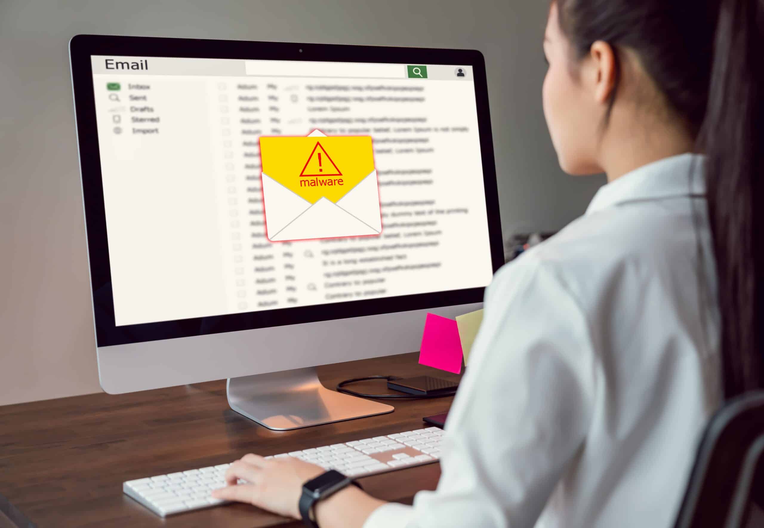 person sitting in front of their computer displaying a danger message