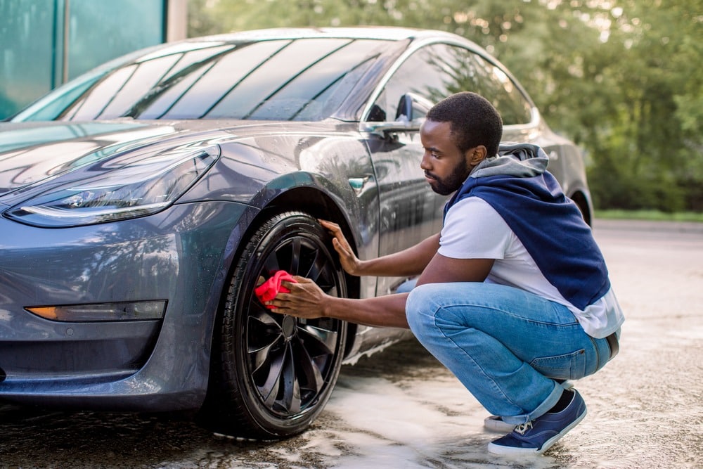 Man cleaning the wheels of his car
